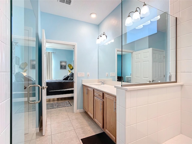 bathroom with tile patterned floors, vanity, and a shower with door