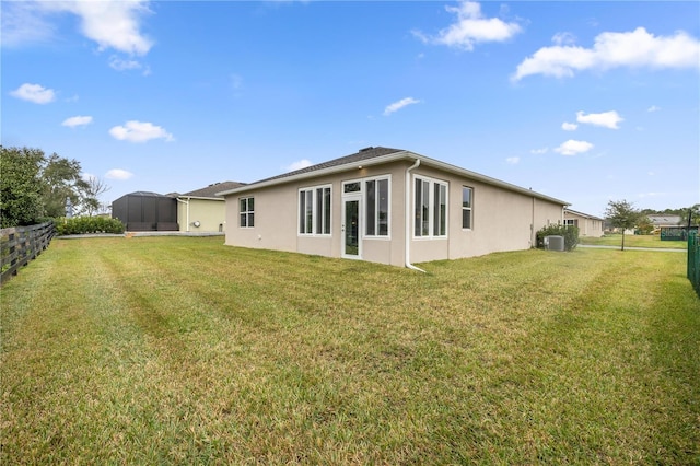 back of property with cooling unit and a yard