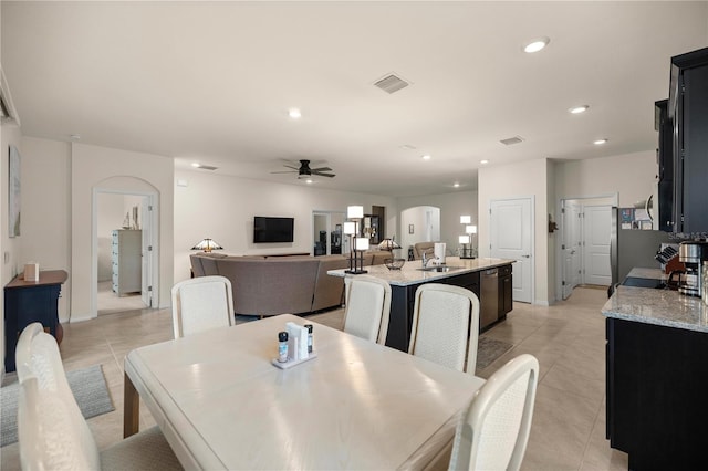 tiled dining area with ceiling fan and sink