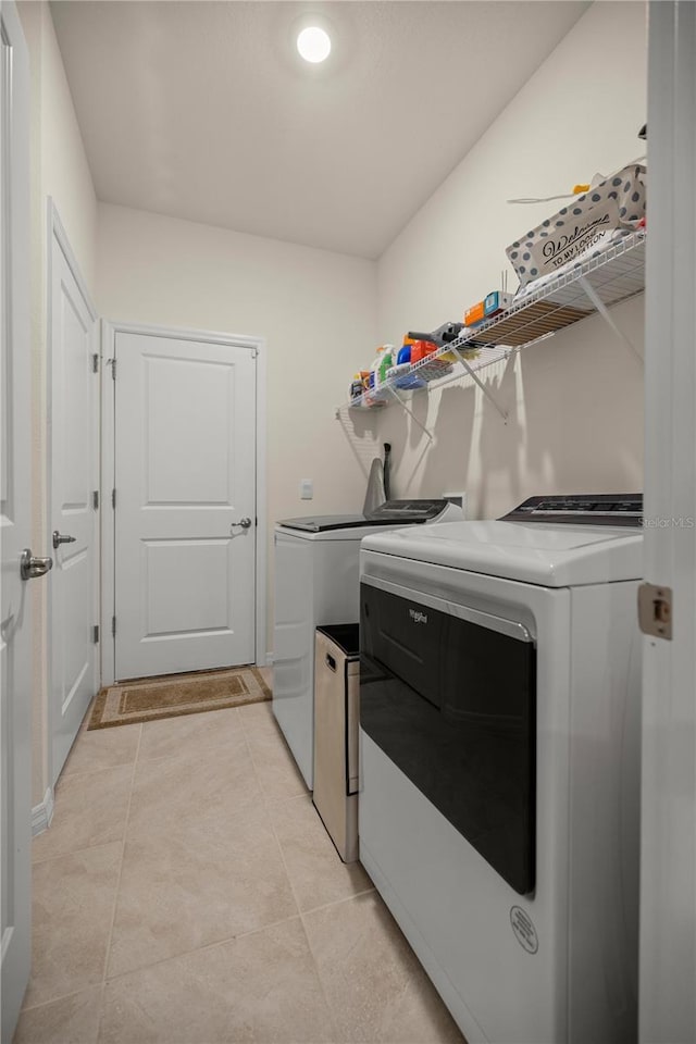 laundry room featuring separate washer and dryer and light tile patterned floors