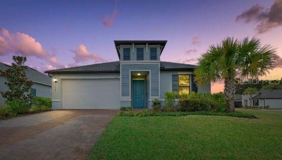 view of front of house with a garage and a yard