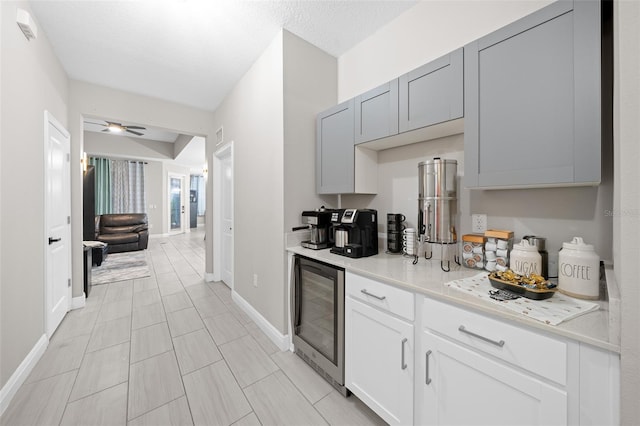 kitchen with wine cooler, ceiling fan, and a textured ceiling