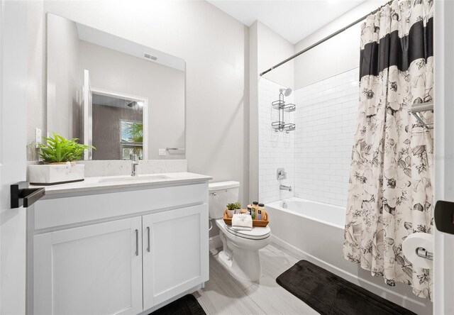 full bathroom featuring vanity, shower / tub combo, and toilet