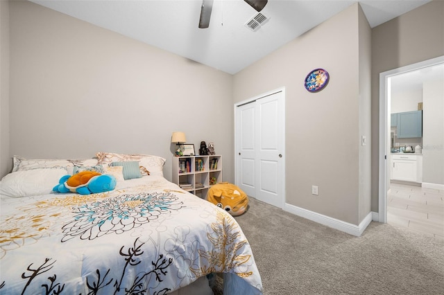 bedroom with ceiling fan, a closet, and light carpet