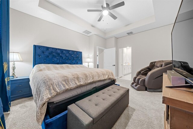 carpeted bedroom featuring a tray ceiling and ceiling fan