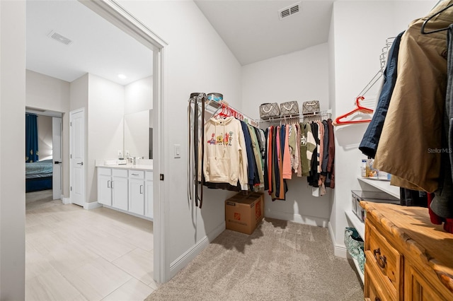 walk in closet featuring light colored carpet