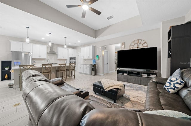 living room with ceiling fan and sink