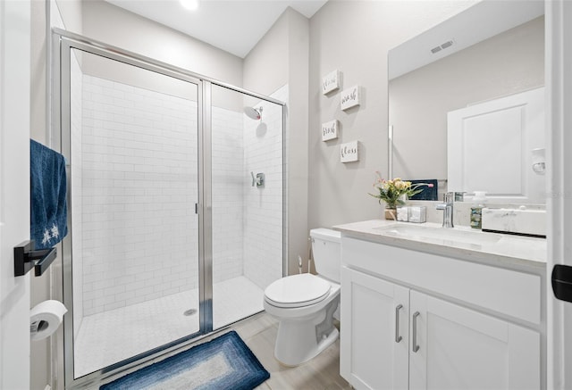 bathroom with tile patterned flooring, vanity, toilet, and a shower with shower door