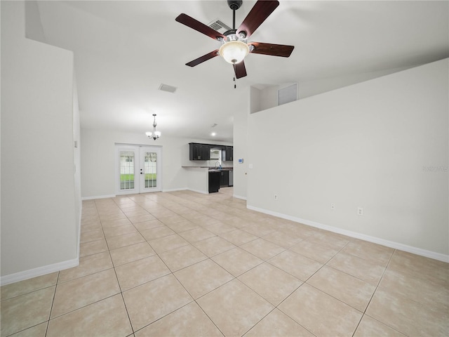 unfurnished living room with vaulted ceiling, french doors, light tile patterned floors, and ceiling fan with notable chandelier