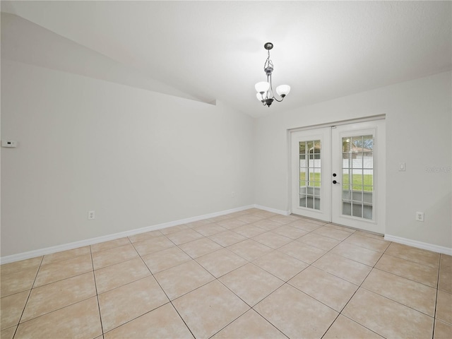 tiled empty room featuring an inviting chandelier, lofted ceiling, and french doors