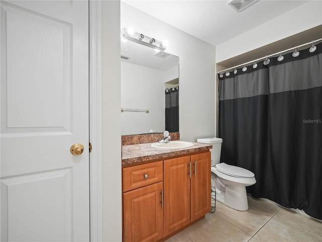 bathroom with tile patterned flooring, vanity, and toilet