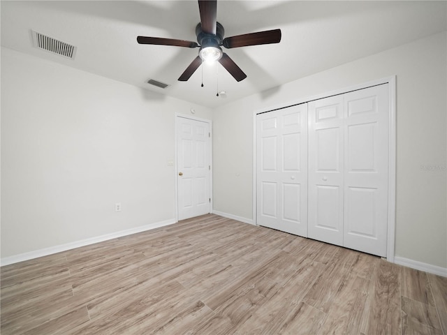 unfurnished bedroom featuring ceiling fan, light wood-type flooring, and a closet