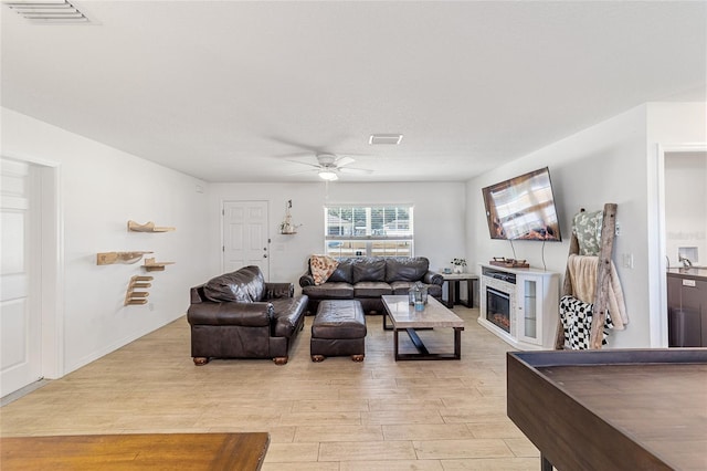 living room with light hardwood / wood-style floors and ceiling fan