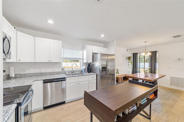 kitchen featuring white cabinetry, sink, appliances with stainless steel finishes, and light hardwood / wood-style flooring