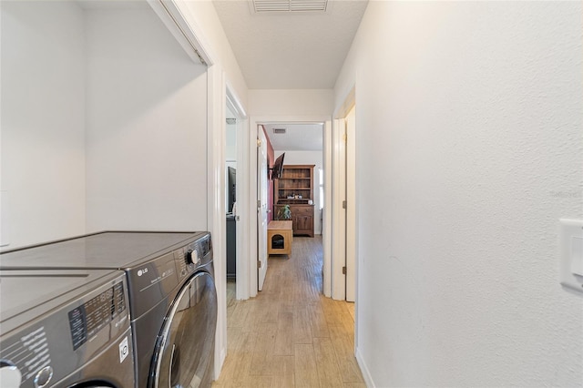 laundry room featuring independent washer and dryer and light wood-type flooring