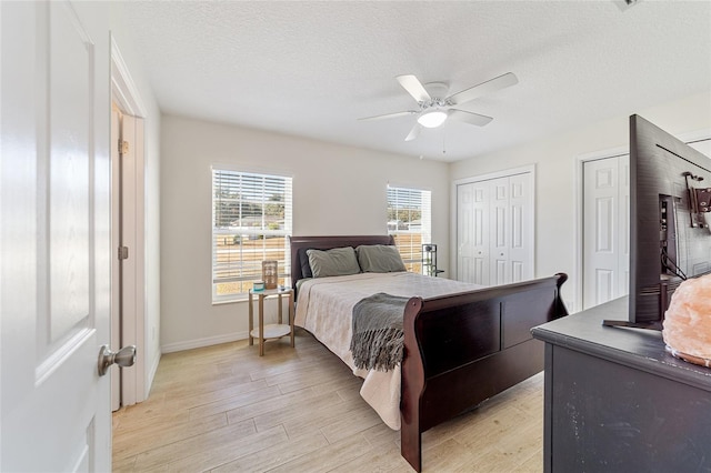 bedroom with a textured ceiling, light hardwood / wood-style flooring, and ceiling fan