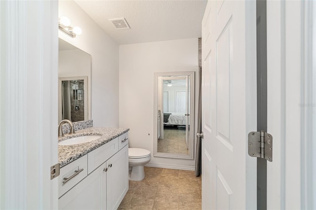 bathroom featuring tile patterned floors, a textured ceiling, vanity, ceiling fan, and toilet