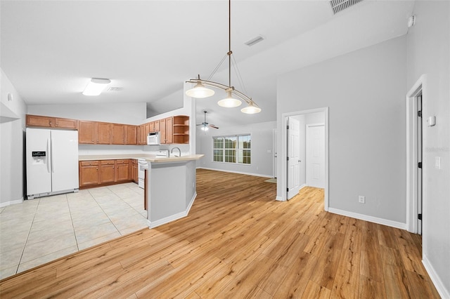 kitchen featuring pendant lighting, white appliances, light hardwood / wood-style floors, and high vaulted ceiling