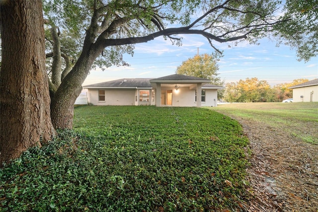 view of front of house featuring ceiling fan and a front yard