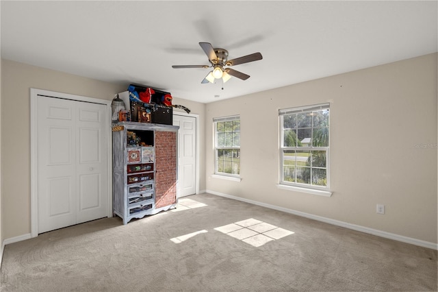 unfurnished bedroom featuring ceiling fan and light colored carpet