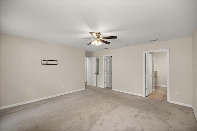 unfurnished bedroom with ensuite bath, ceiling fan, and light colored carpet