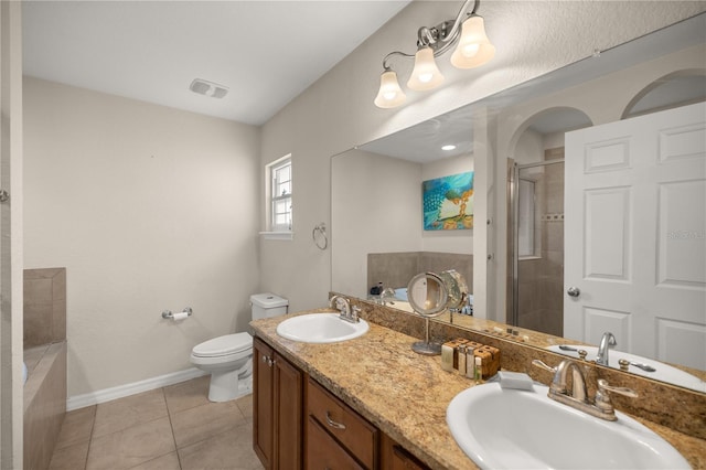 bathroom featuring tile patterned flooring, vanity, a shower with door, and toilet