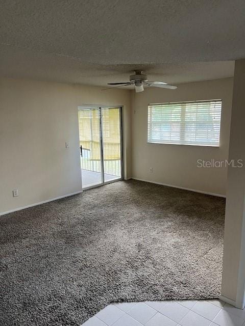 spare room with ceiling fan, light colored carpet, and a textured ceiling