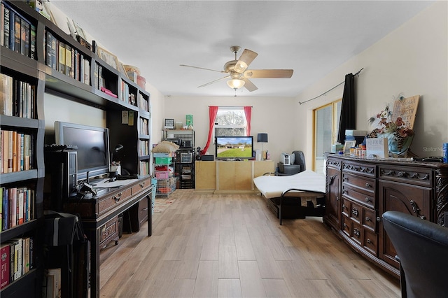 sitting room with light wood-type flooring and ceiling fan