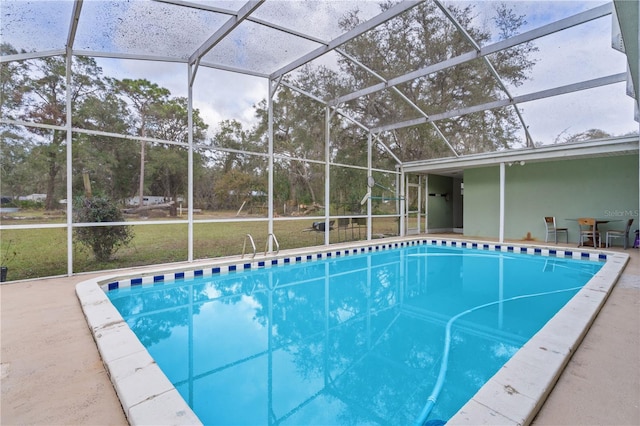 view of swimming pool featuring glass enclosure