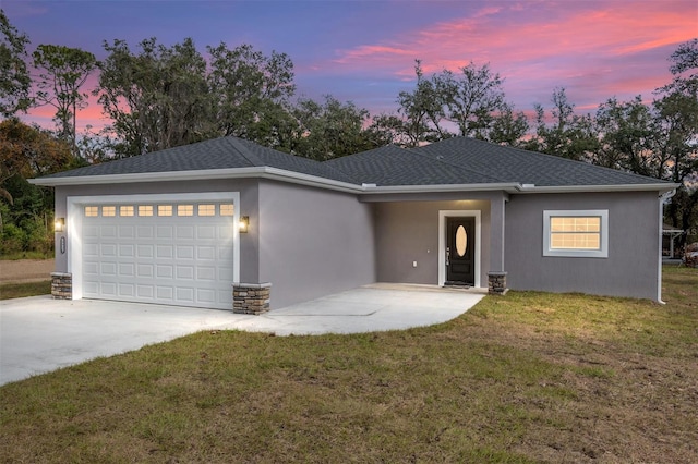 prairie-style home featuring a lawn and a garage