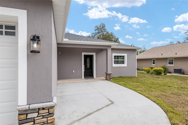 property entrance featuring cooling unit and a yard