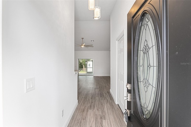 foyer featuring hardwood / wood-style floors and ceiling fan with notable chandelier