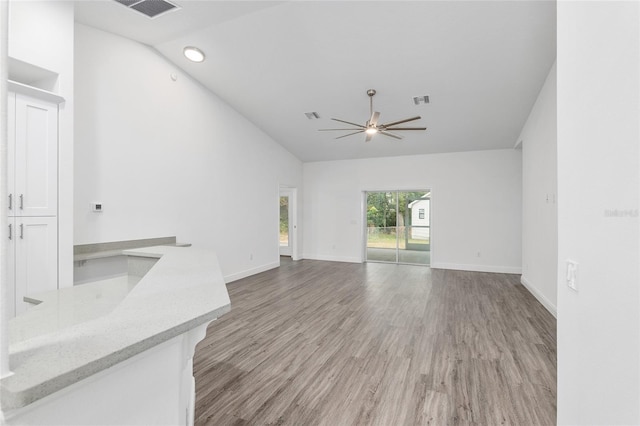 unfurnished living room featuring ceiling fan, light hardwood / wood-style flooring, and vaulted ceiling