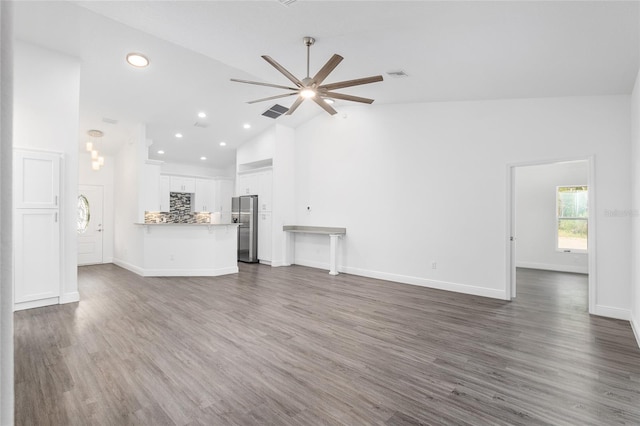 unfurnished living room featuring dark hardwood / wood-style flooring, high vaulted ceiling, and ceiling fan