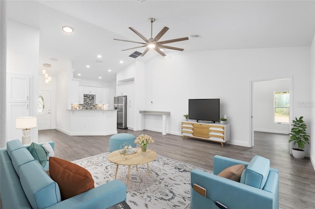 living room with dark hardwood / wood-style floors, high vaulted ceiling, and ceiling fan