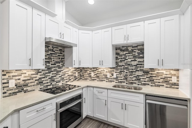 kitchen with white cabinets, appliances with stainless steel finishes, backsplash, and sink