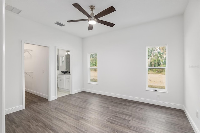 unfurnished room featuring dark hardwood / wood-style floors, ceiling fan, and sink