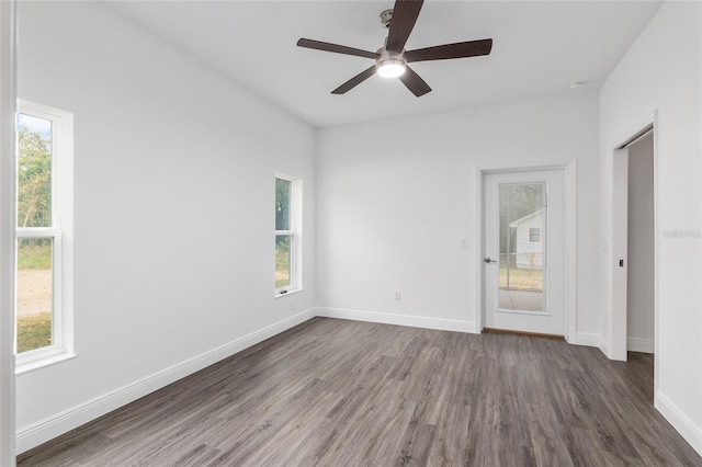 empty room with ceiling fan, dark hardwood / wood-style flooring, and a healthy amount of sunlight