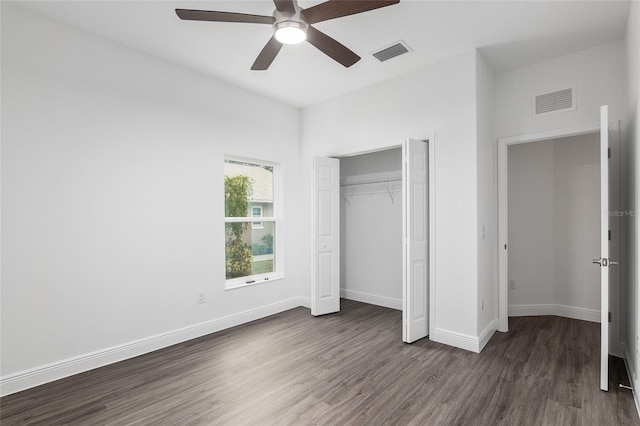 unfurnished bedroom with a closet, dark hardwood / wood-style floors, and ceiling fan