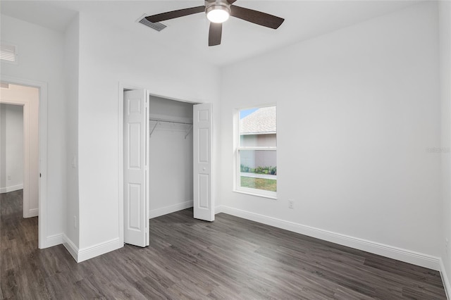 unfurnished bedroom with ceiling fan, dark hardwood / wood-style floors, and a closet