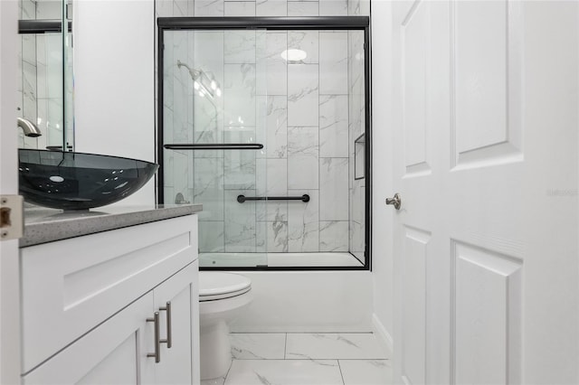 full bathroom featuring combined bath / shower with glass door, vanity, and toilet