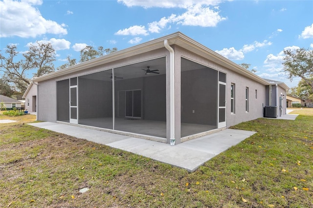 rear view of property with a sunroom, ceiling fan, cooling unit, and a yard