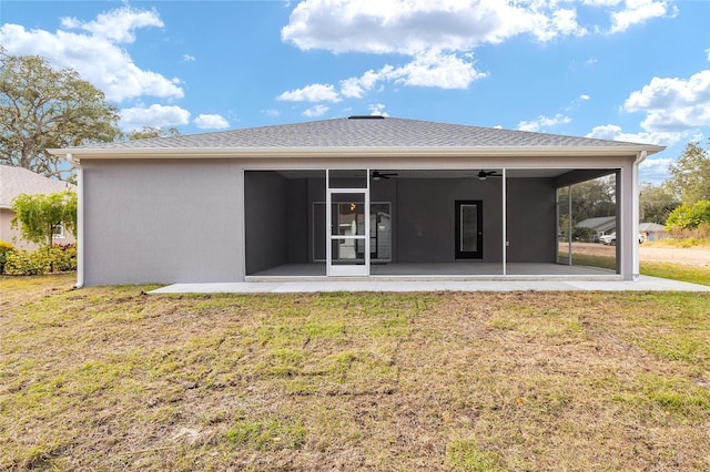 rear view of property with ceiling fan, a yard, and a patio