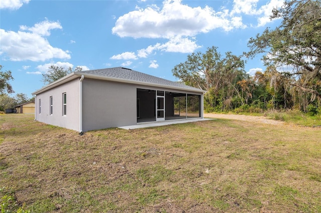 back of house featuring a lawn and a sunroom