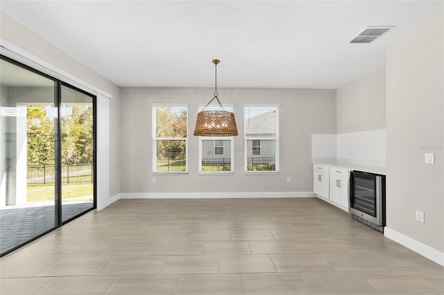 unfurnished dining area featuring wine cooler