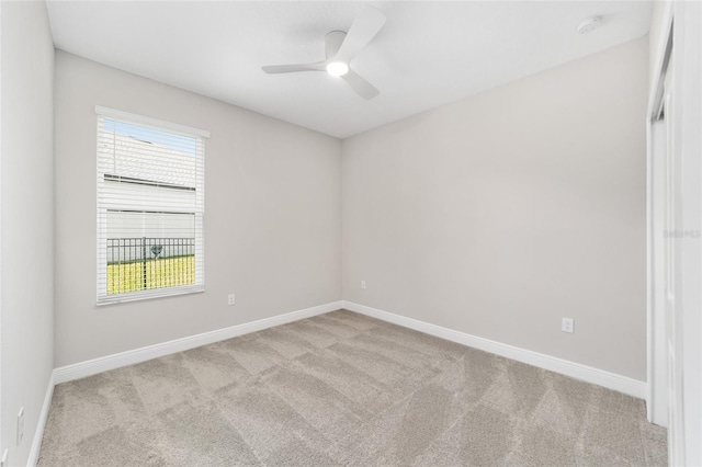 carpeted spare room with ceiling fan