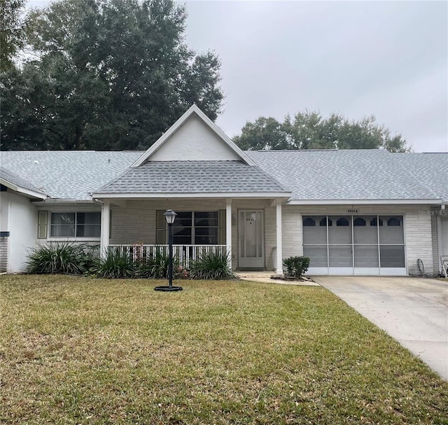 single story home with a porch, a garage, and a front lawn