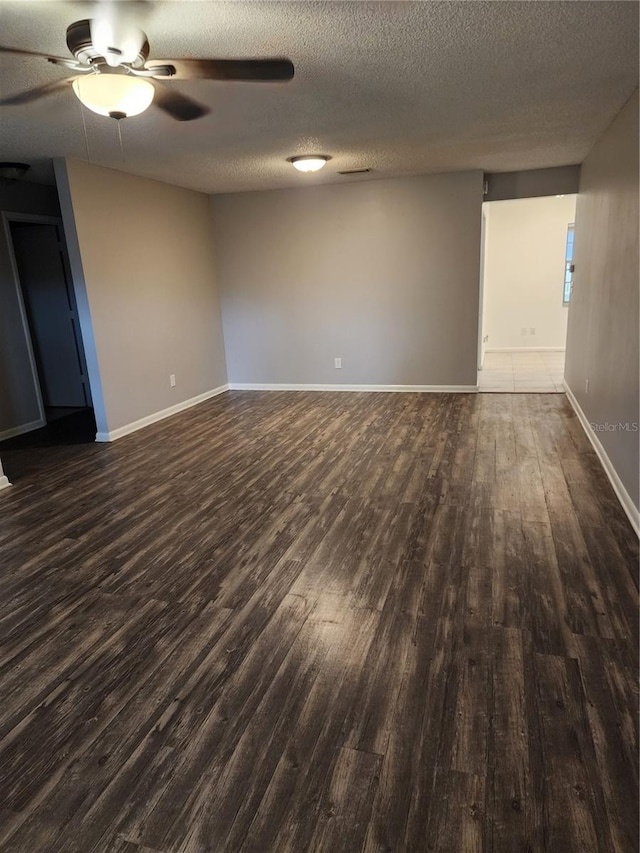 spare room with a textured ceiling, dark hardwood / wood-style flooring, and ceiling fan