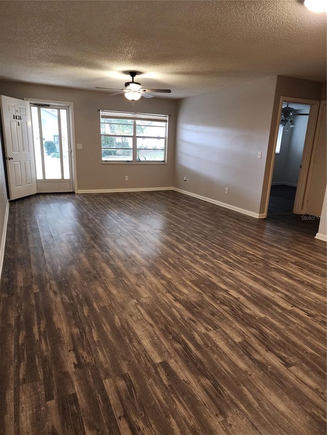 empty room featuring a textured ceiling and dark wood-type flooring