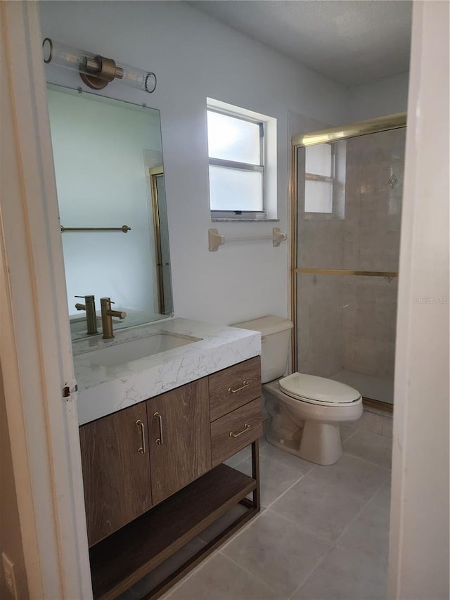 bathroom featuring tile patterned floors, vanity, an enclosed shower, and toilet